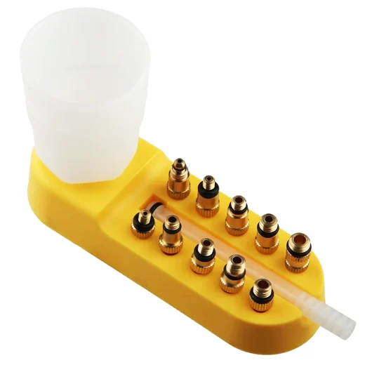 Bike Brake Bleed Kit brass adaptors arranged on a yellow stand beside the funnel