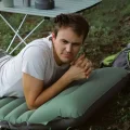 same mattress as North Peak Mattress Pro in use outdoors man resting on inflatable camping mat