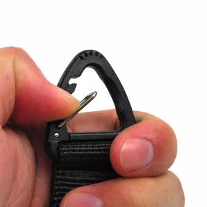 Fingers pressing open the small black hook on the glove strap holder for quick glove attachment