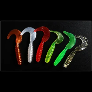 Curly tail soft grub baits in assorted bright and translucent colours on a dark background