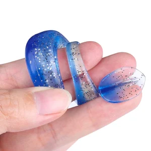 Flexible blue and silver silicone soft bait lure being bent between fingers