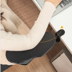 Black clamp on desk arm rest supporting a forearm while using a laptop at a desk