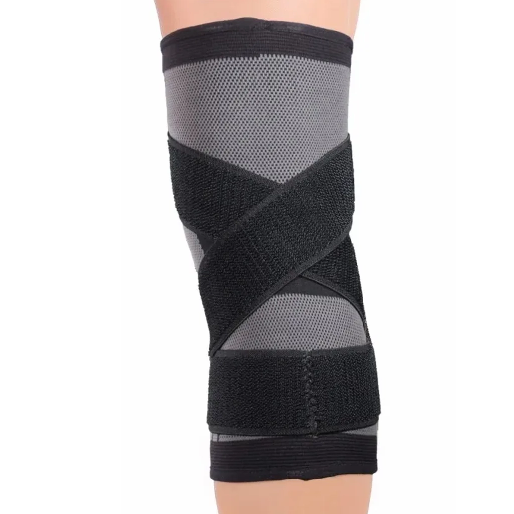 Black and grey knee sleeve worn on a leg showing the rear crossover support straps