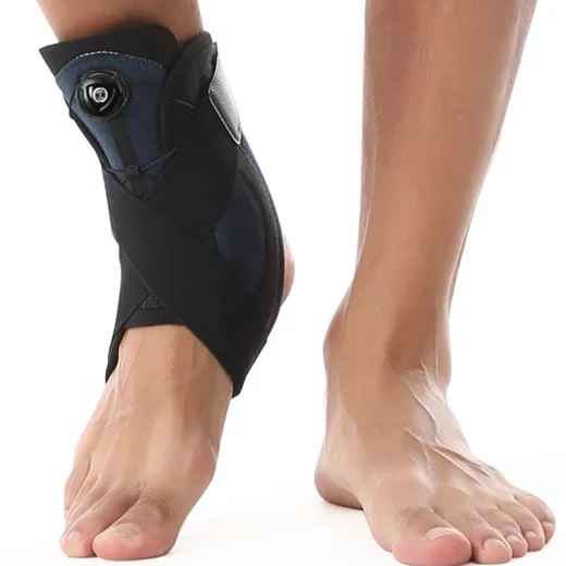 Black and blue ankle brace being worn with the cable adjustment dial visible
