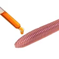 Close-up illustrating scented liquid attractant being added to a ribbed earthworm lure