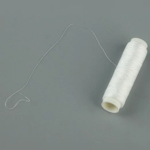 Elastic bait thread partly unwound from the spool to show the fine fishing bait cord
