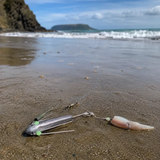 Suckerme 3oz Breakaway Sinker attached to a surfcasting rig on a sandy New Zealand beach