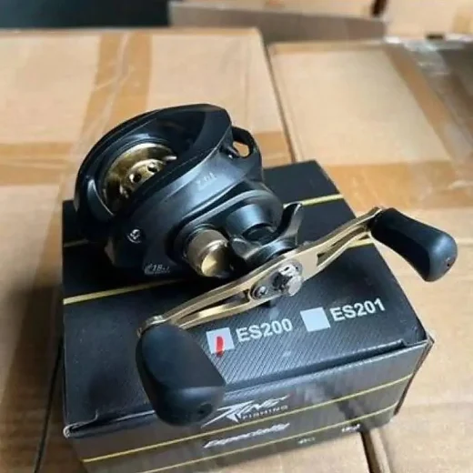 Handle-side view of black and gold fishing reel resting on its box